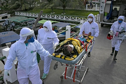 Nhân viên y tế chuyển bệnh nhân mắc COVID-19 tới một bệnh viện ở bang Para, Brazil. (Ảnh: AFP/TTXVN)