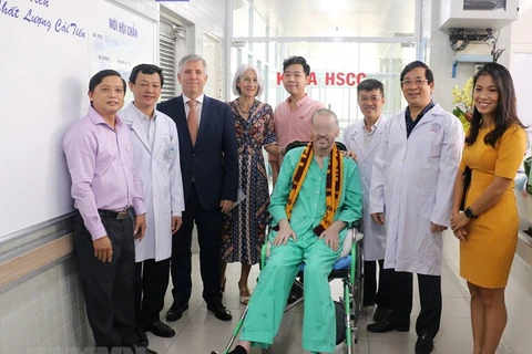 Bệnh nhân 91 chụp ảnh lưu niệm với đại diện Lãnh sự quán Anh tại Thành phố Hồ Chí Minh và các y bác sỹ trong ngày xuất viện. (Ảnh: TTXVN phát)