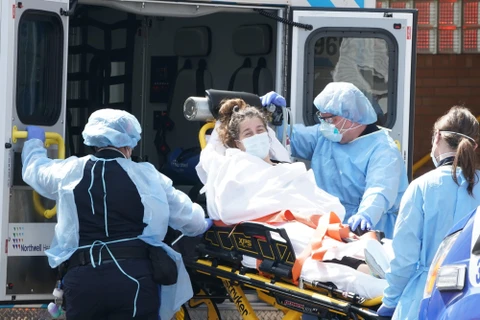 Nhân viên y tế chuẩn bị chuyển bệnh nhân nhiễm COVID-19 tới bệnh viện ở Brooklyn, New York (Mỹ). (Ảnh: AFP/TTXVN)