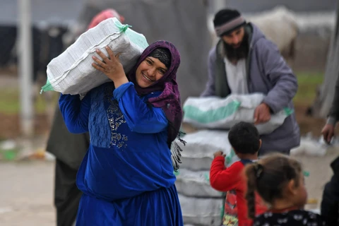 Người tị nạn Syria nhận hàng viện trợ tại trại tị nạn ở thị trấn Mehmediye, Syria, ngày 21/2. (Ảnh: AFP/TTXVN)