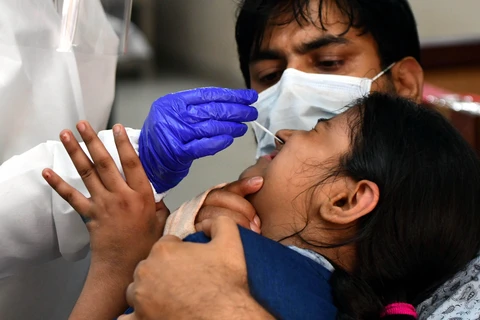 Nhân viên y tế lấy mẫu dịch xét nghiệm COVID-19 cho người dân tại New Delhi, Ấn Độ. (Ảnh: THX/TTXVN)