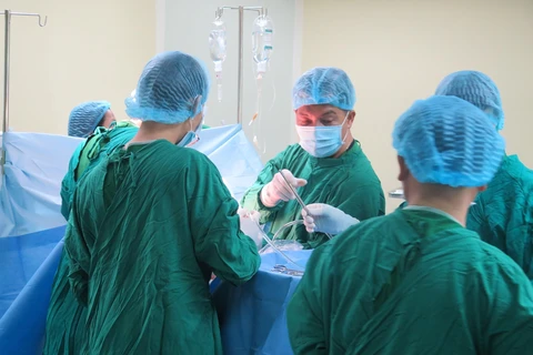 Nạn nhân Lò Thị Nam (36 tuổi, trú Thường Xuân, Thanh Hóa) được các bác sỹ phẫu thuật lồng ngực. (Ảnh: Dư Toán/TTXVN)