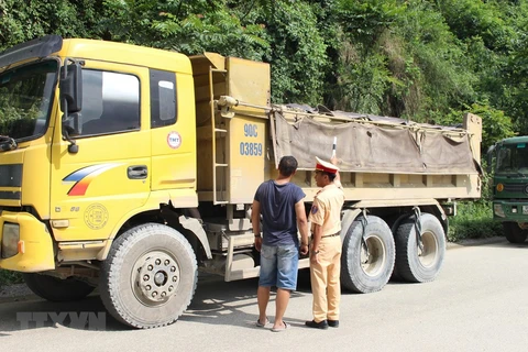 Cảnh sát giao thông kiểm tra một xe tải lưu thông trên đường. (Ảnh minh họa: TTXVN)