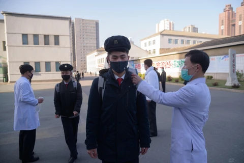 Kiểm tra thân nhiệt phòng lây nhiễm COVID-19 tại trường đại học Y ở Bình Nhưỡng, Triều Tiên. (Ảnh: AFP/TTXVN)