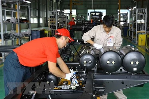 Các công nhân, kỹ sư làm việc tại Nhà máy Sản xuất và lắp ráp ôtô MAZ ASIA. (Ảnh: Đinh Tuấn/TTXVN)