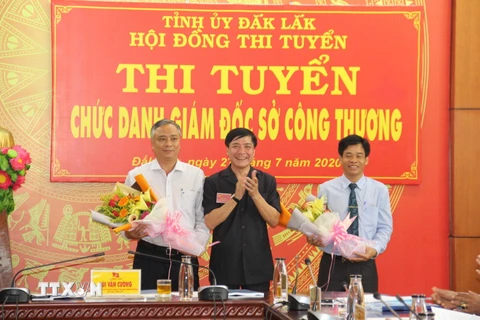 Ủy viên Trung ương Đảng, Bí thư Tỉnh ủy Đắk Lắk Bùi Văn Cường tặng hoa chúc mừng hai ứng viên. (Ảnh: Anh Dũng/TTXVN)