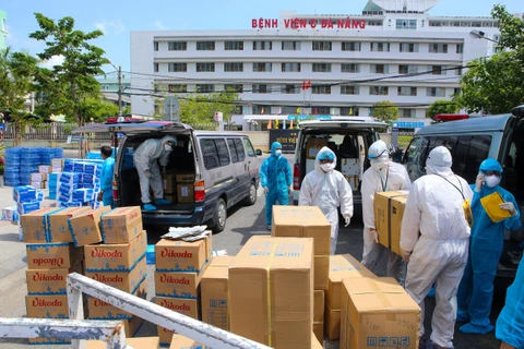 Các nhu yếu phẩm thiết yếu ủng hộ cho đội ngũ y tế và bệnh nhân được bốc dỡ để vận chuyển vào khu vực cách ly ở Bệnh viện C Đà Nẵng. (Ảnh: Trần Lê Lâm - TTXVN)