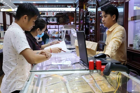 Khách mua bán vàng tại Công ty Kinh doanh vàng bạc Bảo Tín Minh Châu. (Ảnh: Trần Việt - TTXVN)