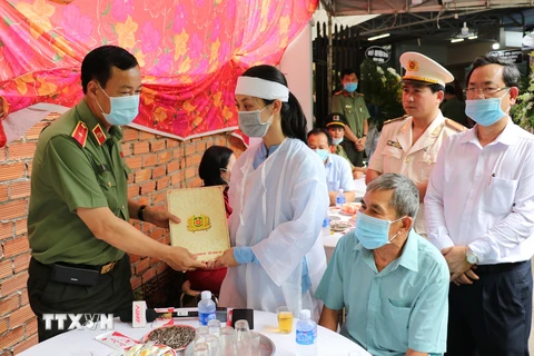 Thiếu tướng Lê Tấn Tới chia buồn và trao tiền hỗ trợ đến gia đình đại úy Lê Thanh Hải. (Ảnh: Chí Tưởng/TTXVN)