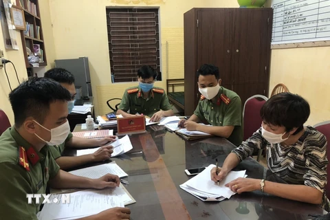 Cơ quan công an huyện Thanh Hà làm việc với đối tượng tung tin giả về dịch bệnh COVID-19. (Ảnh: TTXVN phát)