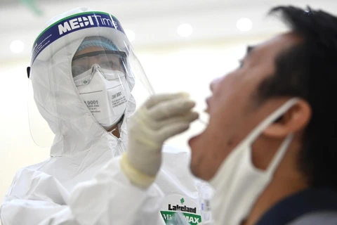 Nhân viên y tế của quận Cầu Giấy, Hà Nội tiến hành lấy mẫu dịch hầu họng để xét nghiệm bằng phương pháp RT-PCR của người dân từ Đà Nẵng trở về. (Ảnh: Thành Đạt/TTXVN)