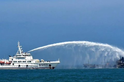 Tàu cứu hộ nỗ lực dập đám cháy sau vụ tàu chở dầu đâm tàu hàng. (Nguồn: Xinhua)