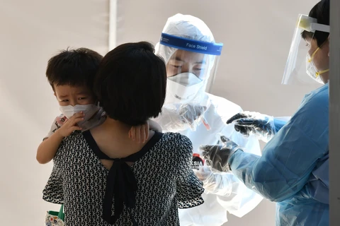 Nhân viên y tế lấy mẫu xét nghiệm COVID-19 cho người dân tại Seoul, Hàn Quốc ngày 18/8. (Ảnh: AFP/TTXVN)