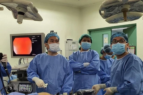 Bác sỹ Bệnh viện Bình Dân Thành phố Hồ Chí Minh thực hiện phẫu thuật bằng robot. (Ảnh: TTXVN phá)