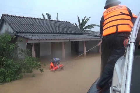 Bộ đội Biên phòng tỉnh Quảng Trị di dời những người dân bị mắc kẹt trong lũ đến nơi an toàn. (Ảnh: Hồ Cầu/TTXVN)