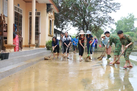 Sư đoàn 324 trợ giúp giáo viên trường Tiểu học Thanh Hà, Thanh Chương dọn dẹp vệ sinh trường lớp. (Ảnh: Bích Huệ/TTXVN)