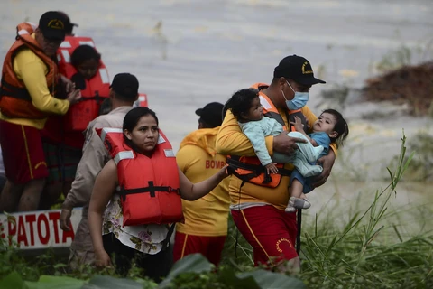 Sơ tán người dân khỏi các khu vực ngập lụt do mưa lớn sau bão Eta tại El Progreso, Honduras. (Ảnh: AFP/TTXVN)