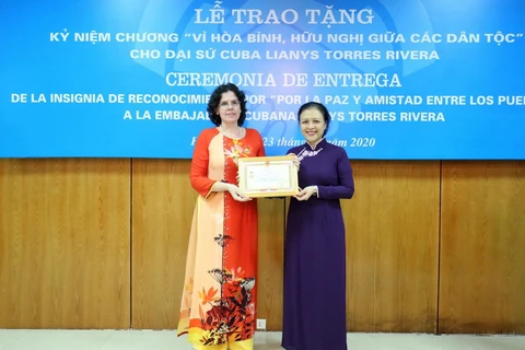 Chủ tịch Liên hiệp các tổ chức Hữu nghị Việt Nam Nguyễn Phương Nga trao Kỷ niệm chương cho Đại sứ Đặc mệnh toàn quyền Cuba tại Việt Nam Lianys Torres Rivera. (Ảnh: TTXVN)