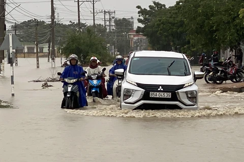 Nước lũ dâng lên trên đường liên xã nối hai xã Phước Nam và Phước Dinh, huyện Thuận Nam gây khó khăn cho lưu thông. (Ảnh: Công Thử/TTXVN)