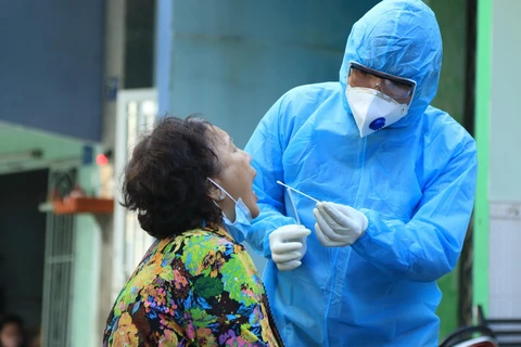 Nhân viên y tế lấy mẫu xét nghiệm người dân trong khu vực Lô E, Lò Gốm (phường 7, quận 6). (Ảnh: Đinh Hằng/TTXVN)