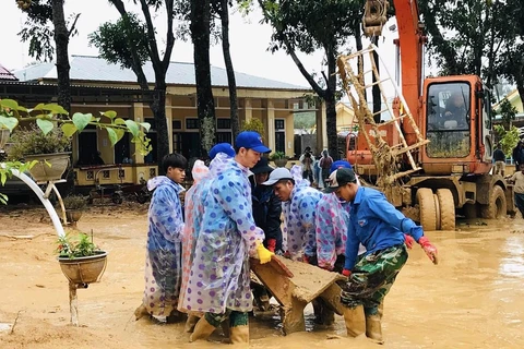 Lực lượng đoàn viên thanh niên xã Hướng Việt khắc phục hậu quả lũ lụt. (Ảnh: Hồ Cầu/TXVN)