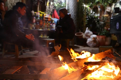Người dân đốt lửa sưởi ấm trên phố Kim Ngưu, Hà Nội. (Ảnh: Hoàng Hiếu/TTXVN)