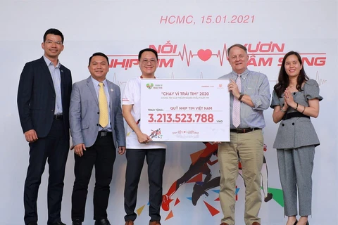 Đại diện Chương trình Nhịp Tim Việt Nam nhận nguồn quỹ vận động được từ Chiến dịch 'Chạy vì trái tim 2020.' (Ảnh: Mỹ Phương/TTXVN)