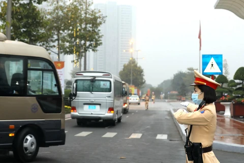 Lực lượng cảnh sát giao thông hướng dẫn đoàn xe chở đại biểu, khách mời đến dự Đại hội. (Ảnh: TTXVN)
