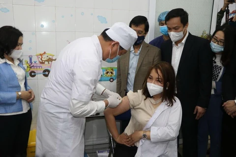 Thứ trưởng Bộ Y Tế Đỗ Xuân Tuyên trực tiếp tiêm vaccine phòng dịch COVID-19 cho một nhân viên y tế của tỉnh Hải Dương. (Ảnh: Mạnh Minh/TTXVN)