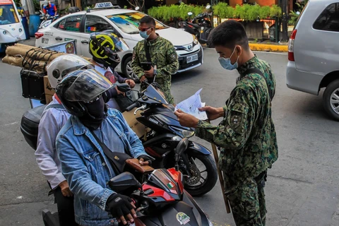 Cảnh sát kiểm tra các phương tiện tại một điểm kiểm soát ở Manila, Philippines, trong bối cảnh dịch COVID-19 diễn biến phức tạp. (Ảnh: THX/ TTXVN)