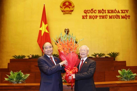 Chủ tịch nước Nguyễn Xuân Phúc tặng hoa Tổng Bí thư Nguyễn Phú Trọng. (Ảnh: Trí Dũng/TTXVN)