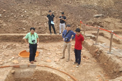 Các đại biểu tìm hiểu các hố khai quật tại khu vực điện Kính Thiên. (Ảnh: Đinh Thuận/TTXVN)