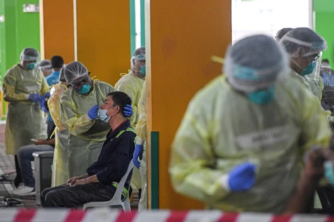 Nhân viên y tế lấy mẫu xét nghiệm COVID-19 tại Singapore. (Ảnh: AFP/TTXVN)