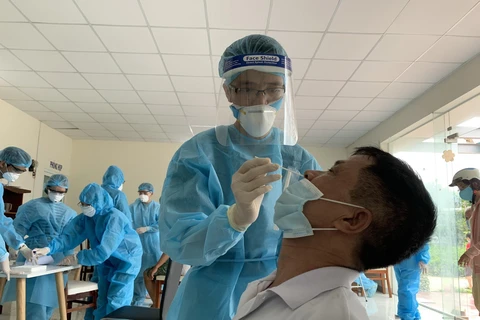 Nhân viên y tế lấy mẫu xét nghiệm COVID-19 cho người dân tại Thành phố Hồ Chí Minh. (Ảnh: TTXVN phát)