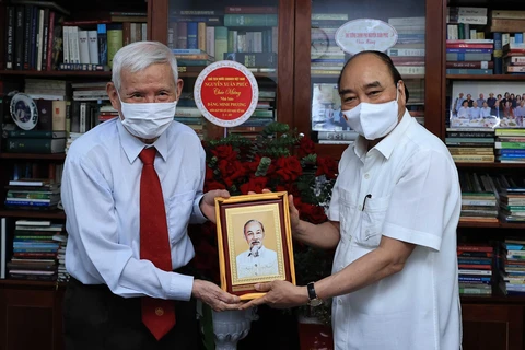 Chủ tịch nước Nguyễn Xuân Phúc thăm nhà báo Đặng Minh Phương. (Ảnh: Thống Nhất/TTXVN)