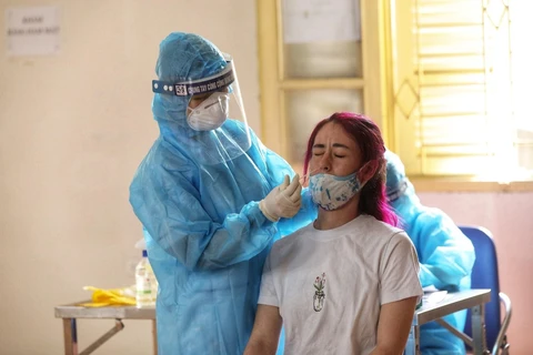 Nhân viên y tế quận Hoàn Kiếm lấy mẫu xét nghiệm COVID-19 cho các trường hợp trở về từ Thành phố Hồ Chí Minh. (Ảnh: Minh Quyết/TTXVN)