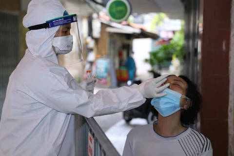 Lực lượng y tế lấy mẫu xét nghiệm SARS-CoV-2 cho những người có nguy cơ cao. (Ảnh: Hoàng Hiếu/TTXVN)