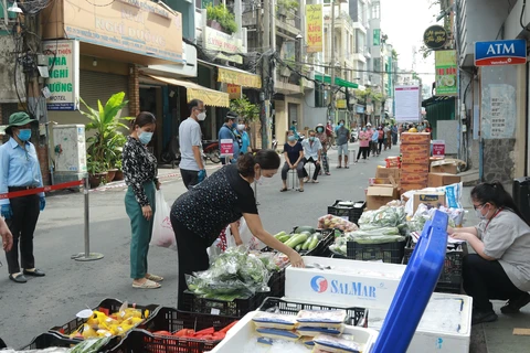 Người dân mua hàng hóa thiết yếu tại một “Phiên chợ lưu động” được tổ chức tại khu phố 3, phường 2, Quận 3, Thành phố Hồ Chí Minh. (Ảnh: Quang Châu/TTXVN)