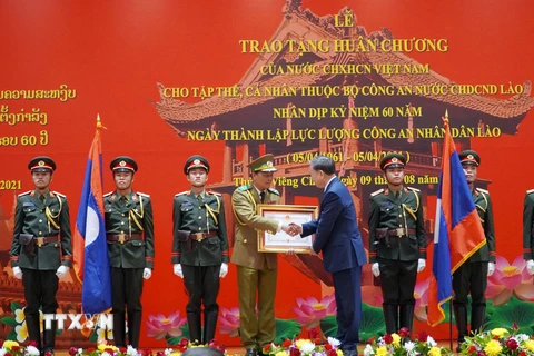 Thay mặt lãnh đạo Đảng, Nhà nước, Đại tướng Tô Lâm trao tặng Huân chương của Nhà nước CHXHCN Việt Nam cho các tập thể, các nhân thuộc lực lượng Công an nhân dân Lào. (Ảnh: Phạm Kiên/TTXVN)
