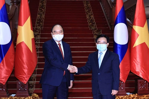 Chủ tịch nước Nguyễn Xuân Phúc hội kiến Thủ tướng Lào Phankham Viphavanh. (Ảnh: Thống Nhất/TTXVN)
