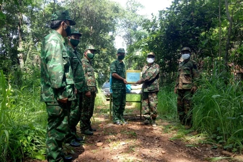 Đồn biên phòng Ia Nan (Bộ chỉ huy Bộ đội biên phòng tỉnh Gia Lai) tổ chức gặp hẹp trao đổi tình hình biên giới và trao hỗ trợ hàng hóa phòng chống COVID-19 cho lực lượng bảo vệ biên giới Campuchia. (Ảnh: Hồng Điệp/TTXVN)