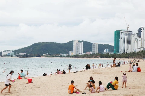 Bãi biển Nha Trang đã nhộn nhịp trở lại trong ngày đầu tiên cho phép tắm biển. (Ảnh: Tiên Minh/TTXVN)