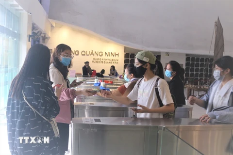 Du khách đến Bảo tàng tỉnh Quảng Ninh thực hiện khai báo y tế, thực hiện các biện pháp phòng, chống dịch COVID-19. (Ảnh: Thanh Vân/TTXVN) 