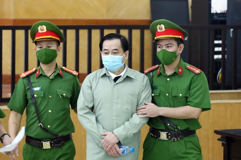 Lực lượng chức năng dẫn giải bị cáo Phan Văn Anh Vũ đến phiên tòa xét xử. (Ảnh: Phạm Kiên/TTXVN)