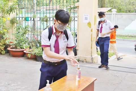 Trường THPT Trưng Vương (Quận 1) bố trí khu vực rửa tay khuẩn ngoài cổng trường. (Ảnh: Hồng Giang/TTXVN)