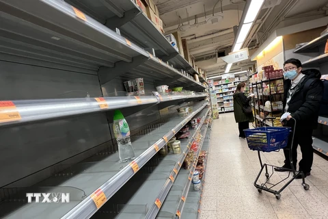 Người dân đứng tần ngần trước kệ bán mỳ tôm đã trống trơn tại siêu thị Parknshop, Hong Kong, ngày 2/3. (Ảnh: Mạc Luyện/TTXVN)