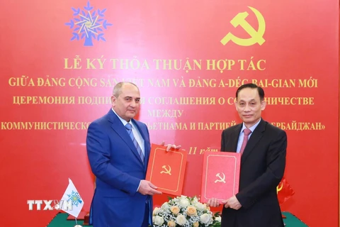 Trưởng Ban Đối ngoại Trung ương Lê Hoài Trung và Phó Chủ tịch Đảng Azerbaijan Mới Tahir Budagov trao bản thoả thuận hợp tác giữa hai Đảng. (Ảnh: Phương Hoa/TTXVN)