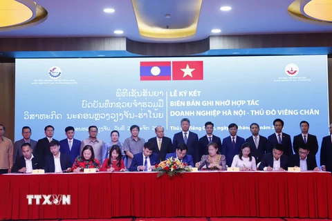 Ký biên bản ghi nhớ hợp tác giữa các doanh nghiệp Hà Nội và Vientiane tại Hội nghị. (Ảnh: Phạm Kiên/TTXVN)
