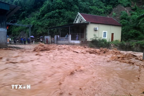 Nhiều nhà dân và các cơ quan đơn vị tại khối 1 thị trấn Mường Xén, huyện Kỳ Sơn (Nghệ An) bị chia cắt do nước lũ chảy xiết. (Ảnh: TTXVN)