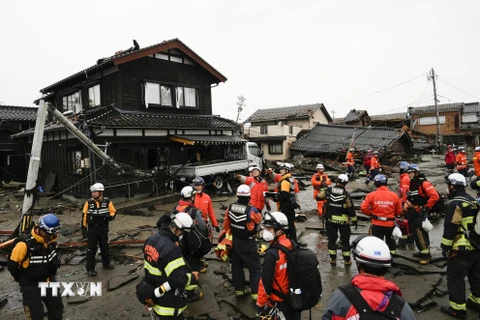 Cảnh sát và lính cứu hỏa tìm kiếm người mắc kẹt trong đống đổ nát của những ngôi nhà bị sập sau động đất tại tỉnh Ishikawa, Nhật Bản ngày 3/1/2024. (Ảnh: Kyodo/TTXVN)